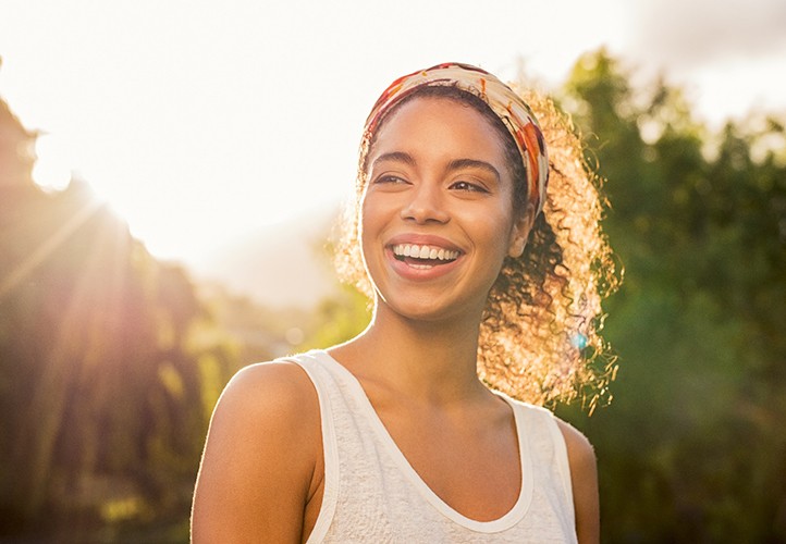 woman smiling outside in sunshine
