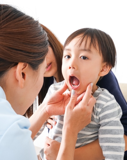 Children's dentist examining a toddler's mouth