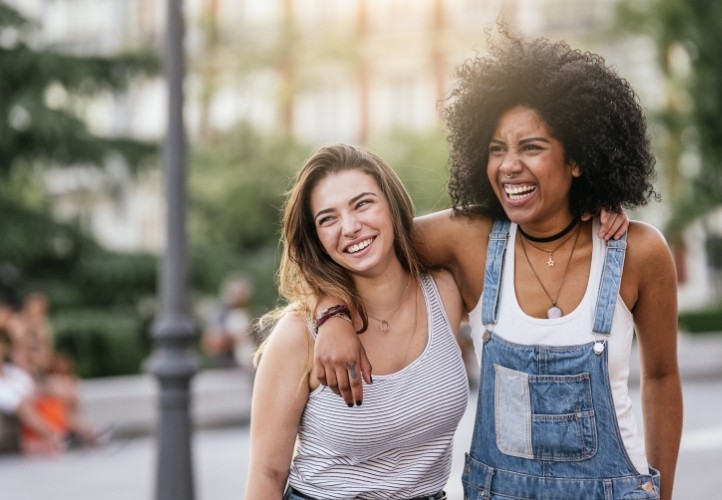 Two young woman smiling outdoors after cosmetic dentistry in Saint Peters