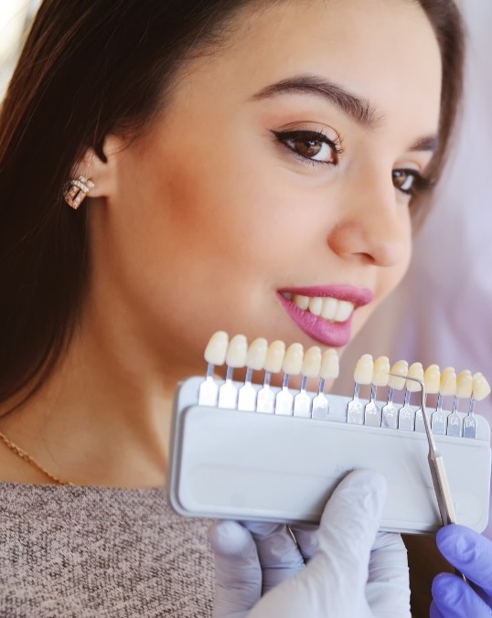 Young woman trying on veneers with cosmetic dentist