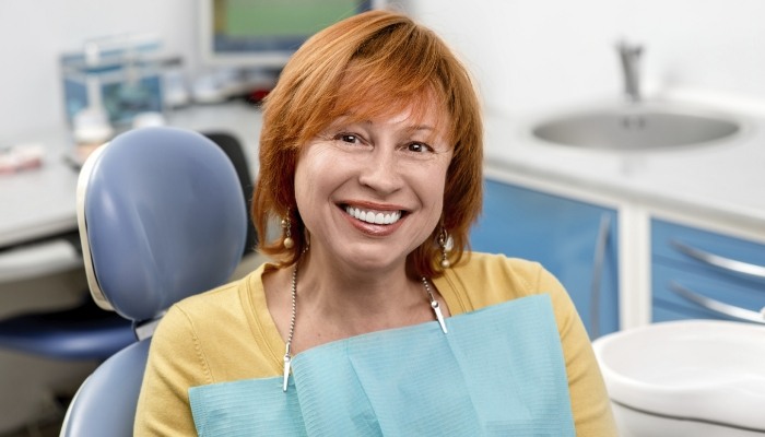 Smiling older redheaded woman in dental chair