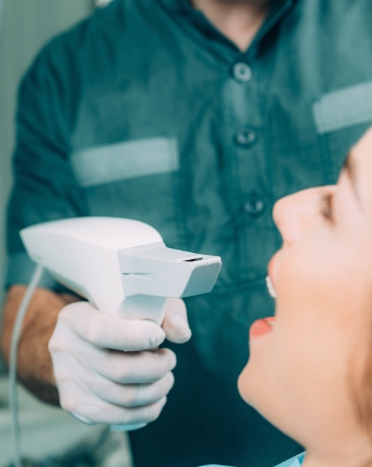 Dentist placing a cavity detection system tool in the mouth of a dental patient