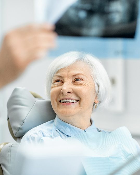 patient looking at dentist explaining X-ray