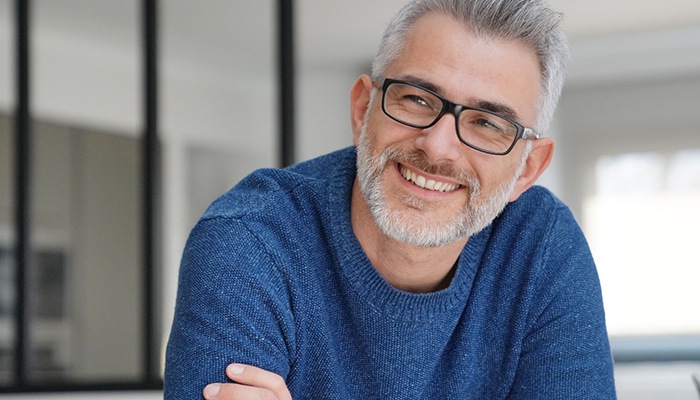 man smiling with arms crossed