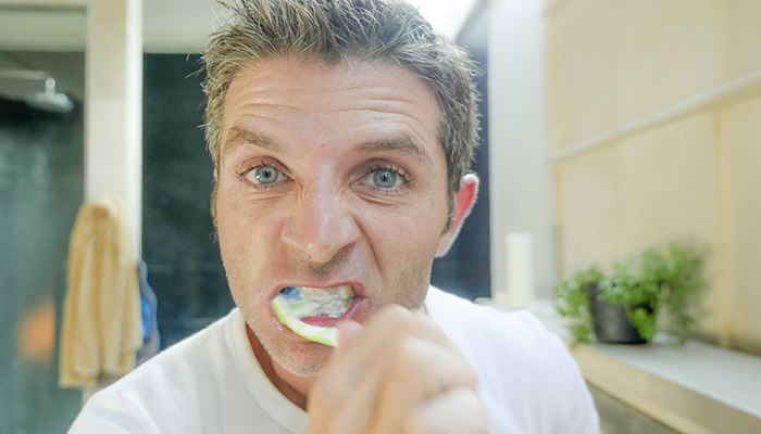 Man brushes teeth