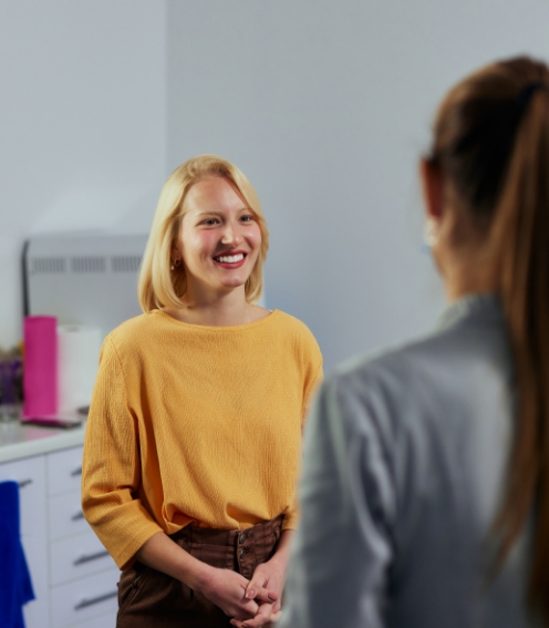 Woman in yellow sweater talking to her dentist