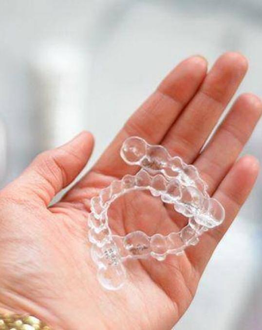 Person holding two Invisalign trays in their hand