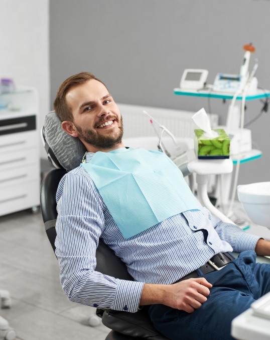 Smiling man with beard sitting in dental chair