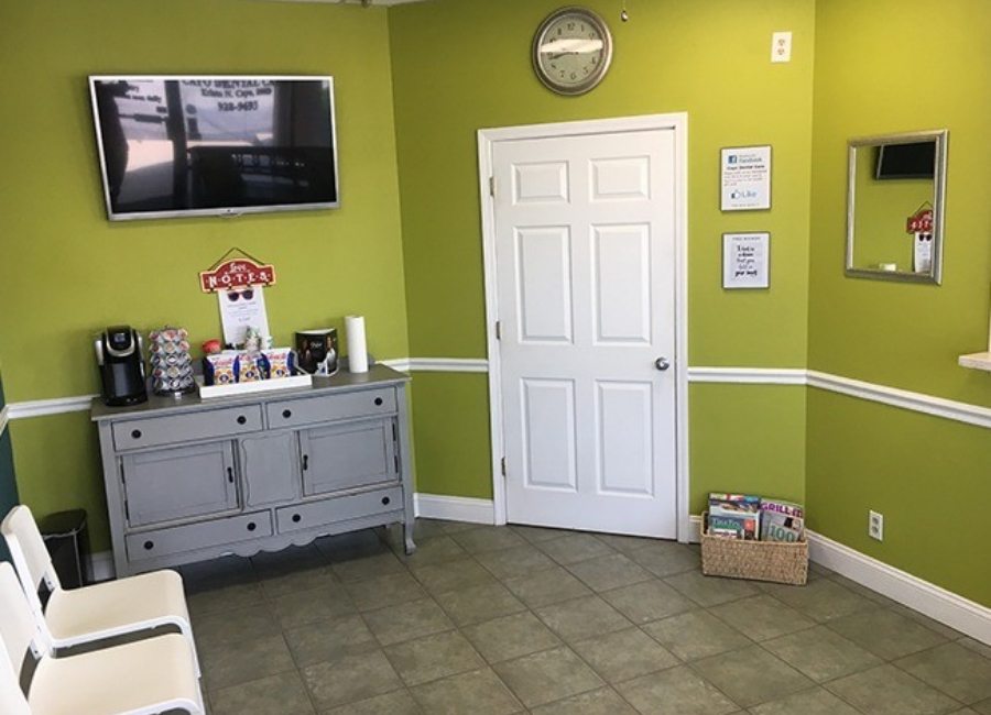 Waiting room with light green walls at Klassik Smiles