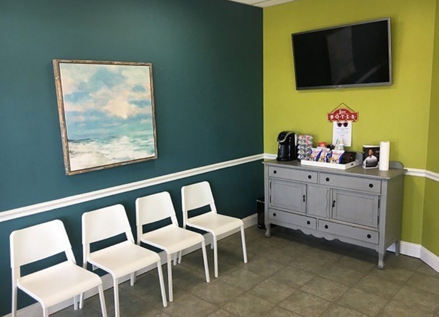 Dental office waiting room with painting of ocean on wall
