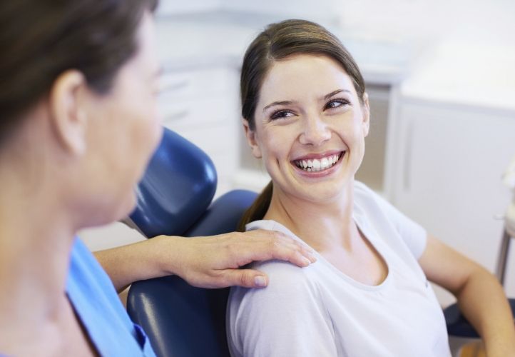 Dentist placing hand on shoulder of patient before providing dental services in Saint Peters