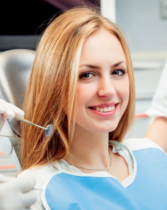 Young blonde woman smiling in dental chair before gum disease treatment