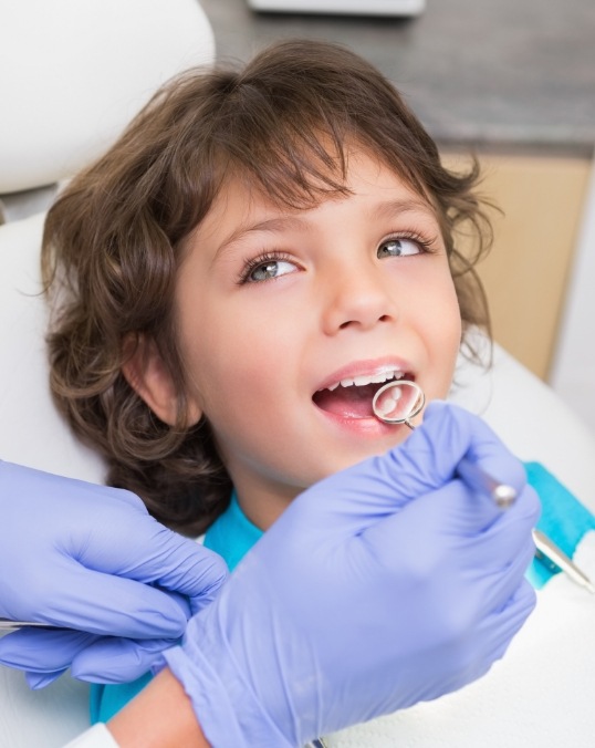 Child with dental mirror in mouth during dental checkup