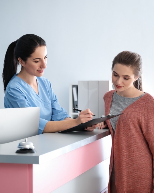 Dental team member showing a clipboard to a patient