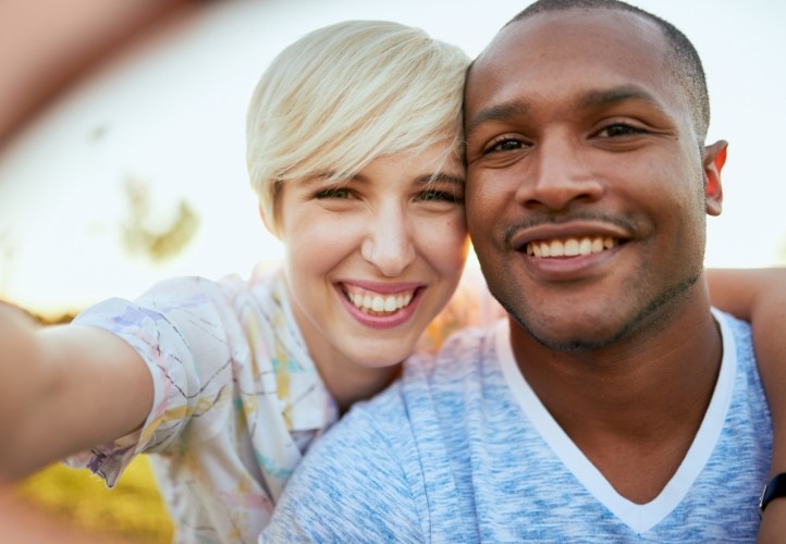 Man and woman smiling outdoors with tooth colored fillings in Saint Peters