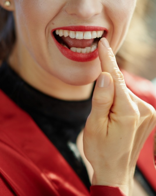 Smiling woman touching her tooth