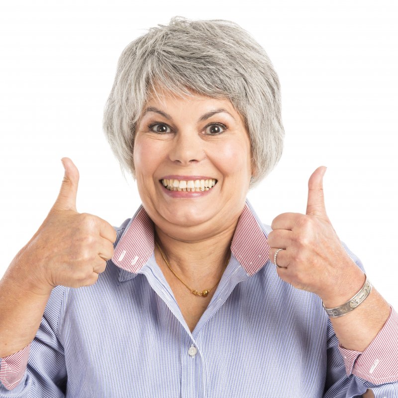 older woman smiling with thumbs up