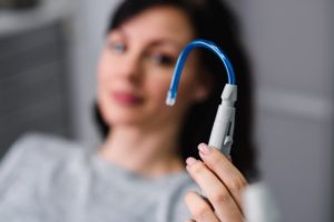 patient holding a dental suction device