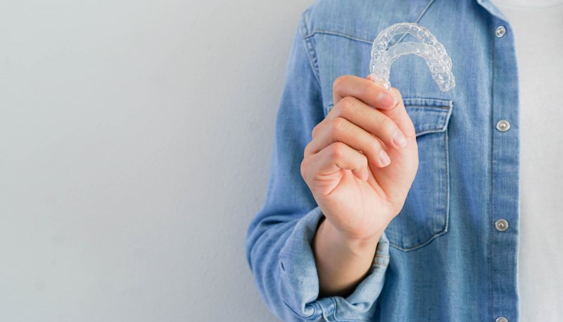 Closeup of teen holding Invisalign aligners