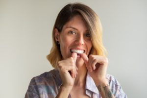 woman putting in Invisalign tray 